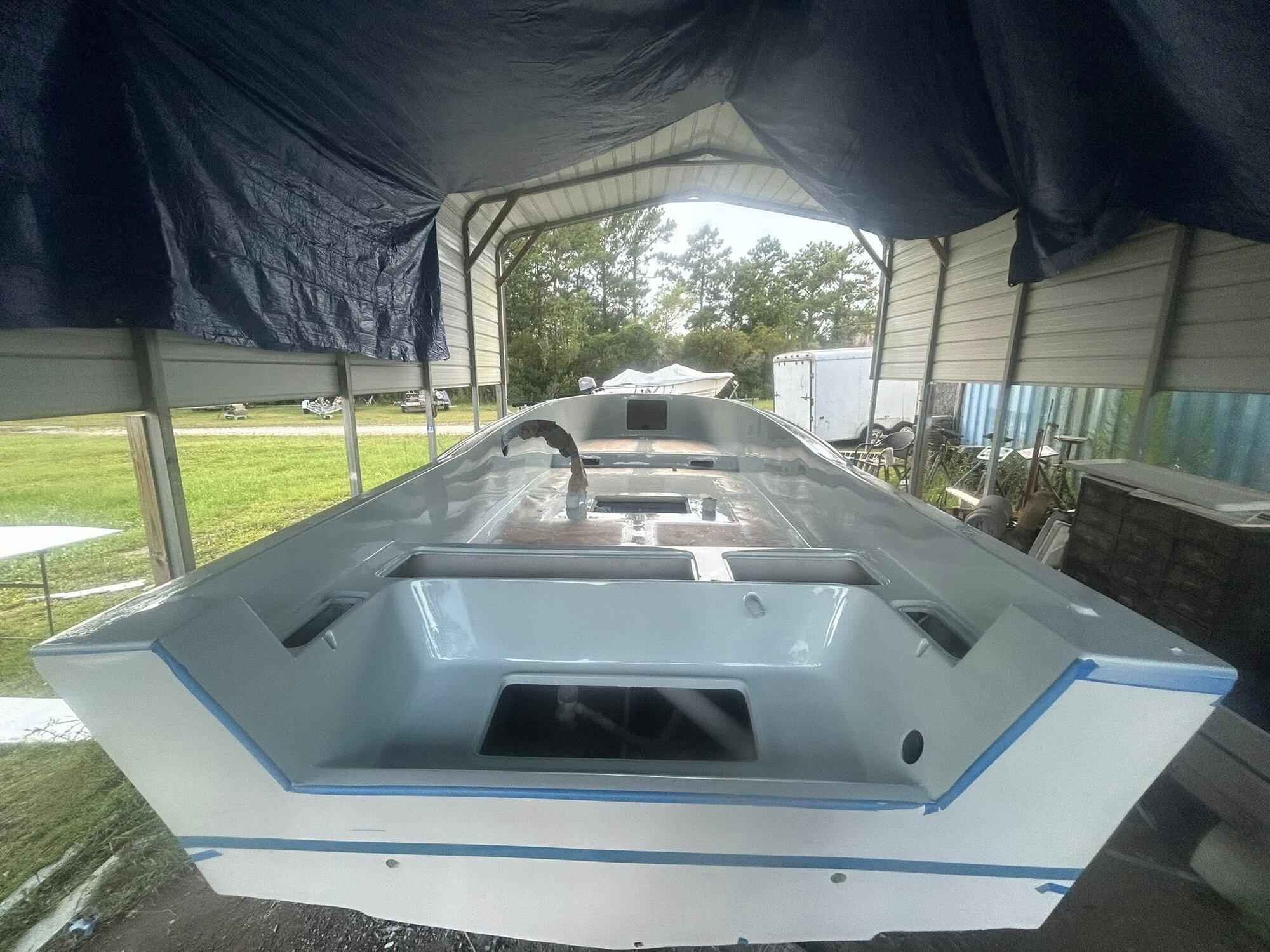 Same interior after full fiberglass rebuild with freshly painted gray surface, ready for hardware reinstall